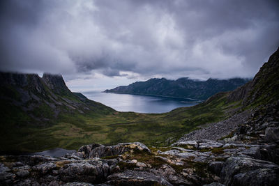 Scenic view of sea and mountains against cloudy sky