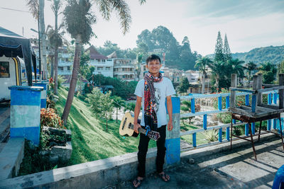 Portrait of smiling man standing against plants