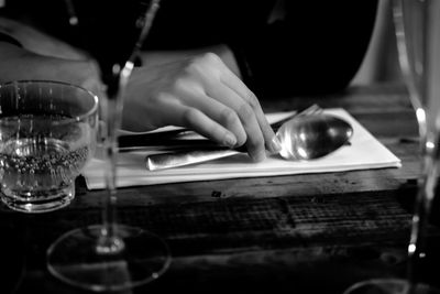 Cropped image of hand with spoons at table