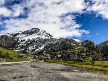Road amidst buildings against sky