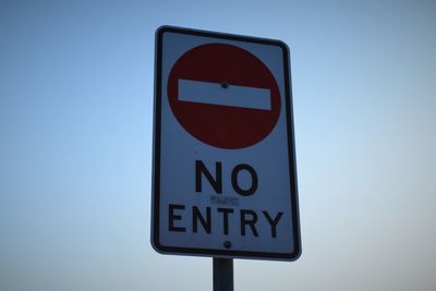 Close-up of road sign against clear sky