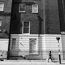 Rear view of woman walking on building