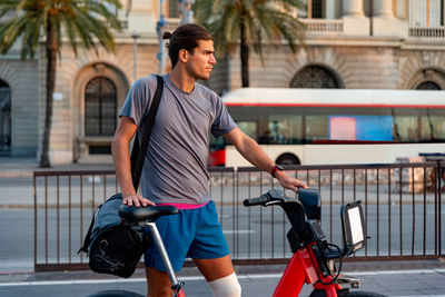 Full length of man with bicycle on street in city