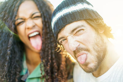 Close-up of man with woman sticking out tongue