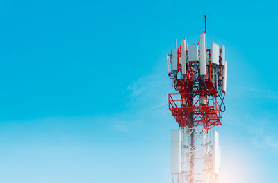 Low angle view of communications tower against blue sky