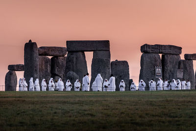 People wearing traditional clothes while standing by rock formations