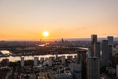 High angle view of city buildings against sky during sunset