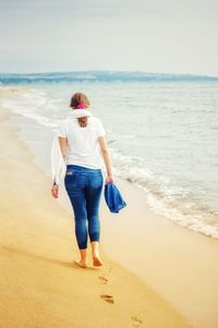 Full length rear view of man standing on beach