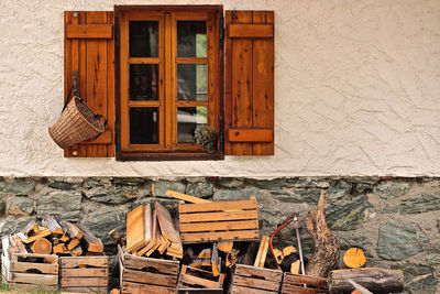 Stack of logs against building