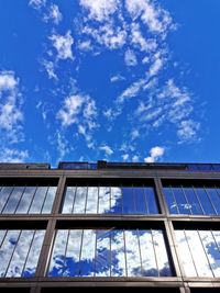 Low angle view of glass building against sky