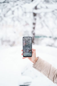 Person holding smart phone in snow