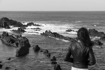 Rear view of woman standing on beach