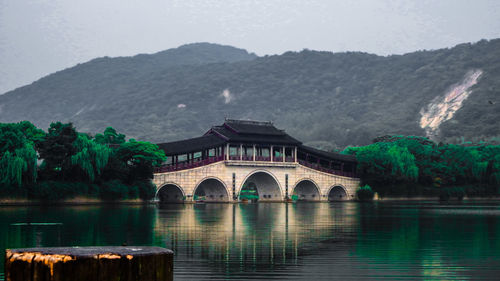 Arch bridge over lake against mountains