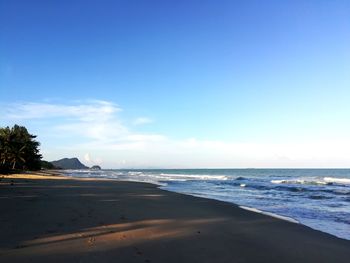 Scenic view of beach against blue sky