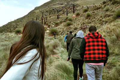 Rear view of people walking on mountain road