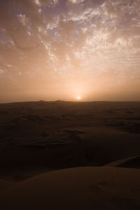 Scenic view of desert against sky during sunset