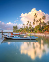Boats moored in water against sky