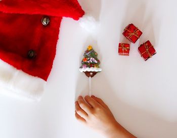 Cropped hand of child holding christmas cookie on table