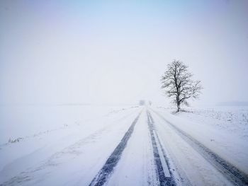 Snow covered field against clear sky