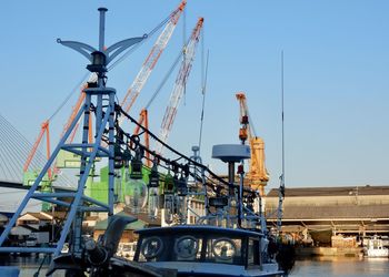 Low angle view of cranes against clear sky