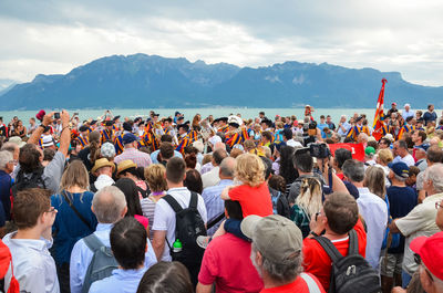 Group of people standing on mountain against sky