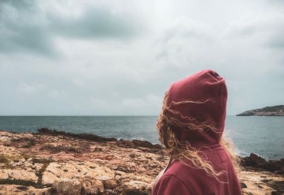 Rear view of woman looking at sea against sky