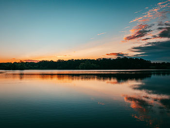 Scenic view of lake against sky at sunrise 