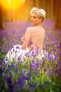 Young woman with yellow flowers on field