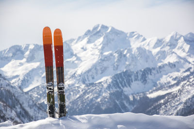 Close-up of skis against snow covered mountains 