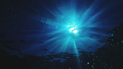 Illuminated light seen through water in sea