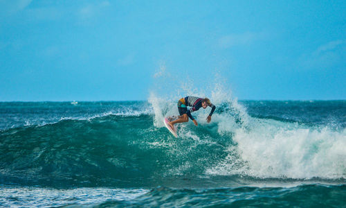 Man surfing on sea against sky