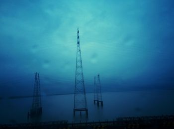 High section of electricity pylon against blue sky