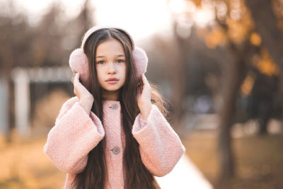 Portrait of kid girl 10-12 year old with long blonde hair wear casual jacket in park outdoor.