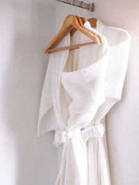 Close-up of white bathrobe hanging on wall