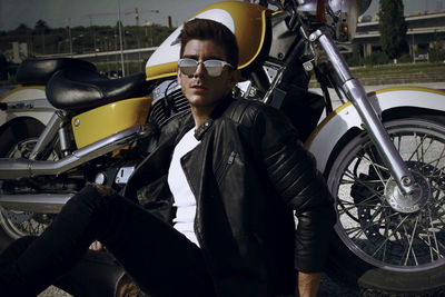 Handsome man sitting by motorcycle