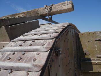 Low angle view of old rusty metallic structure against sky