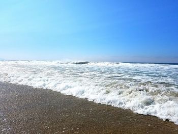 Scenic view of wavy sea against clear sky