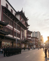 People walking on street against buildings in city