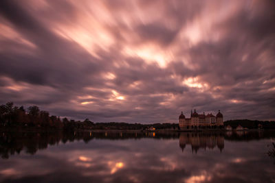 Reflection of buildings in lake during sunset