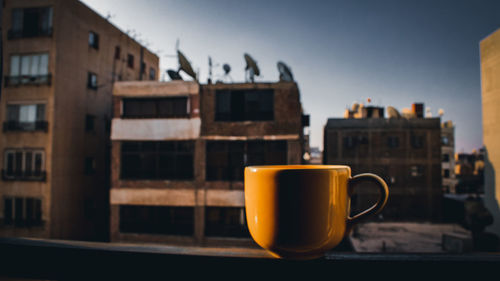 Coffee cup on table against sky