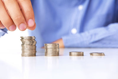 Cropped image of hand holding coins on table