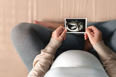 Midsection of woman photographing on sofa