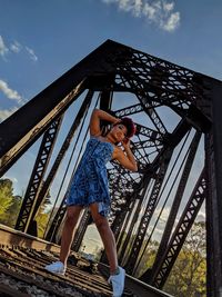 Low angle view of woman standing against sky