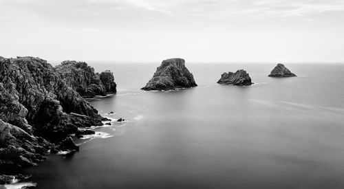 Panoramic view of rock formation in sea against sky