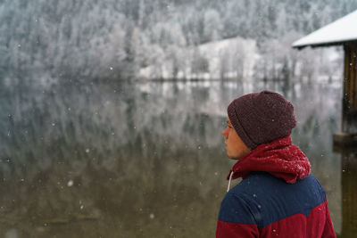 Close-up of man in warm clothing at lake against mountain