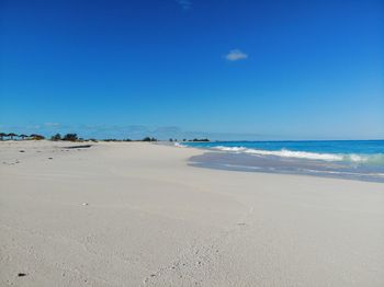 Scenic view of beach against blue sky