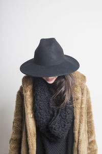 Midsection of woman wearing hat against white background