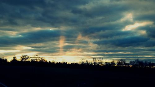 Silhouette of landscape against cloudy sky