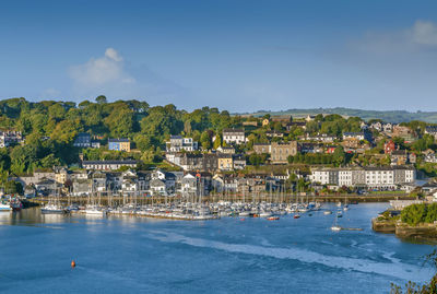 Scenic view of town by sea against sky