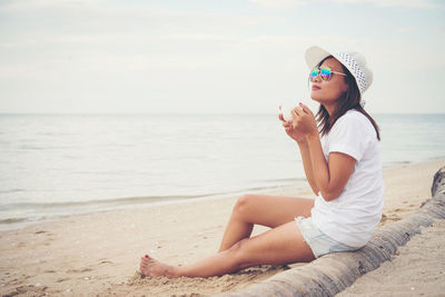 Woman having coffee at beach 